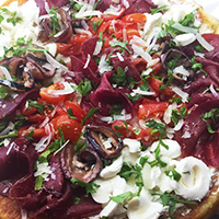 Pizza bresaula, mozzarella, ciliegini, scaglie di grana, melanzane